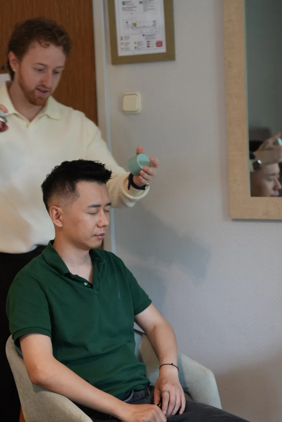 Ricky seated at the hotel while the hairstylist works.