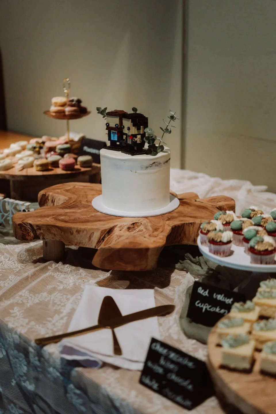 Wedding cake and sweets table, with LEGO figures on top of the cake.