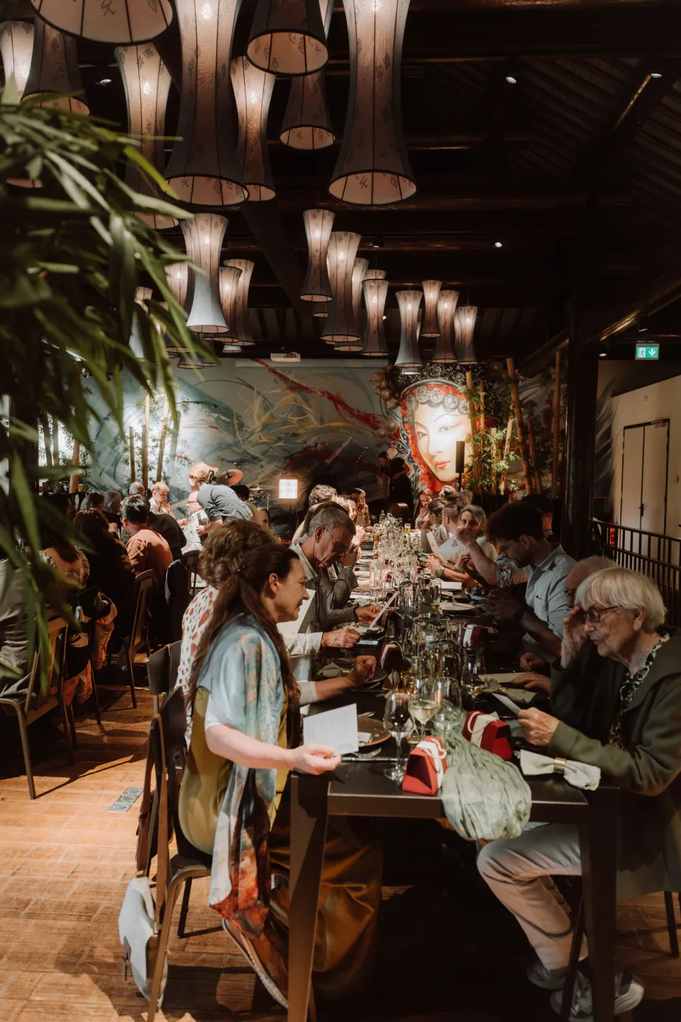 Guests sharing dinner along the tables beneath the pavilion’s lights.