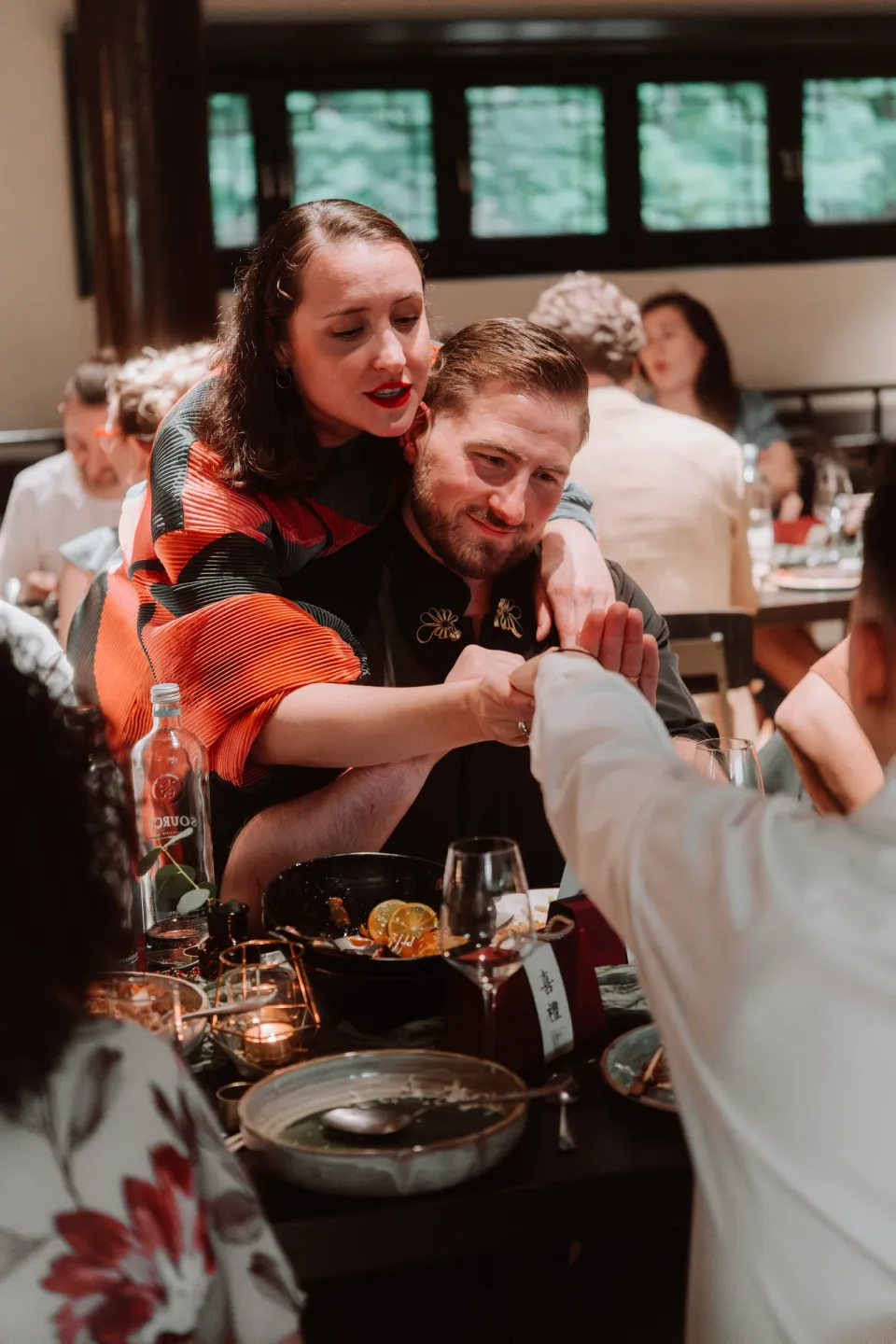 Guests sharing a laugh at the dinner table.