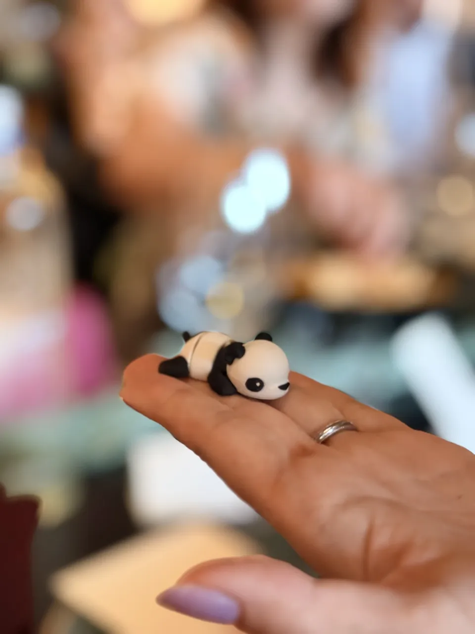 A tiny 3D-printed panda held in a hand.